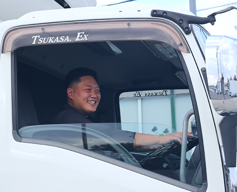 トラックを運転する社員の写真